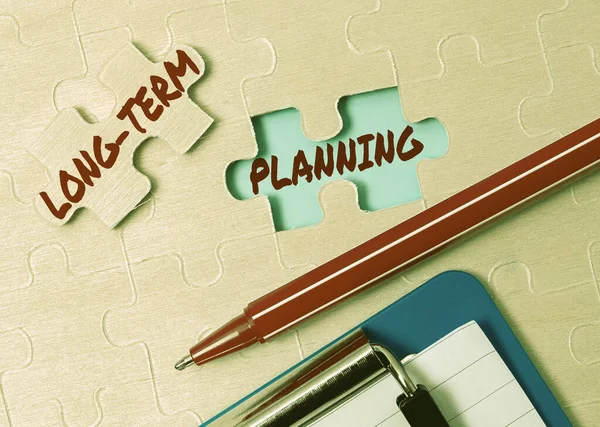 Writing displaying text Long Term Planning. Concept meaning Establish Expected Goals five or more years ahead Building An Unfinished White Jigsaw Pattern Puzzle With Missing Last Piece — Stock Photo, Image