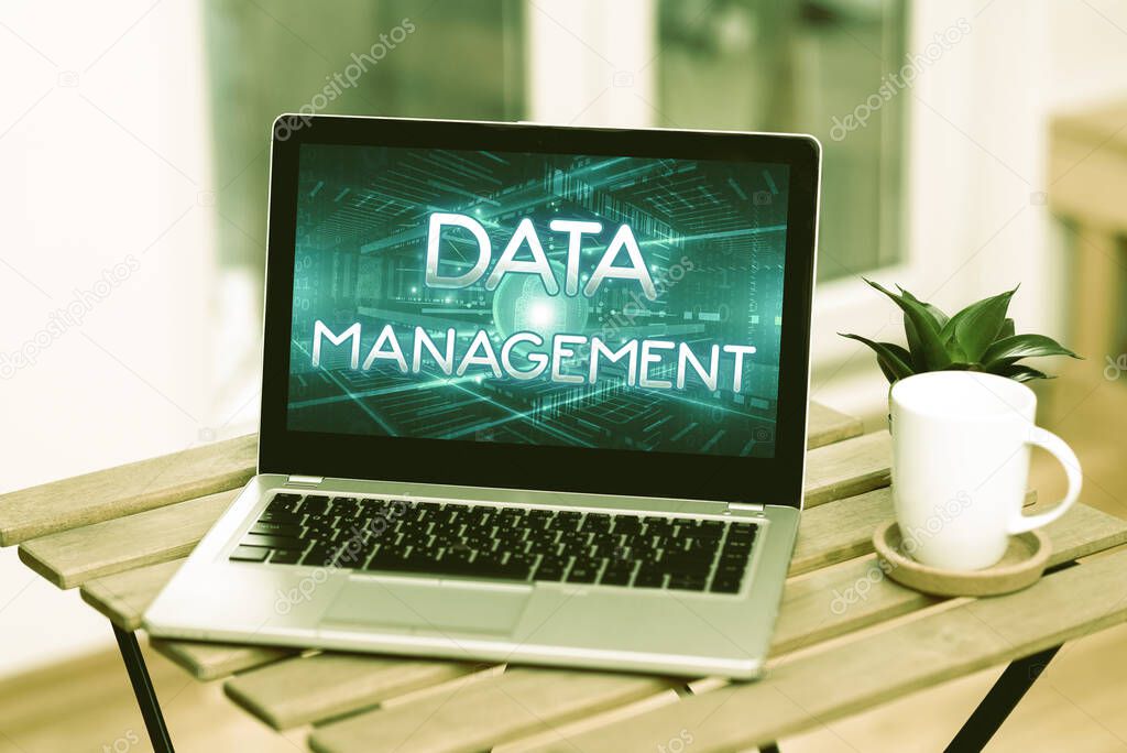 Text sign showing Data Management. Word for The practice of organizing and maintaining data processes Laptop Resting On A Table Beside Coffee Mug And Plant Showing Work Process.