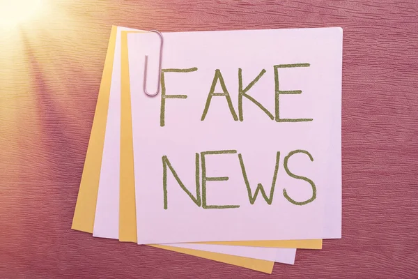 Writing displaying text Fake News. Business idea false information publish under the guise of being authentic news Multiple Assorted Collection Office Stationery Photo Placed Over Table