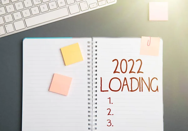 Text sign showing 2022 Loading. Concept meaning Advertising the upcoming year Forecasting the future event Keyboard Over A Table Beside A Notebook And Pens With Sticky Notes — Stockfoto