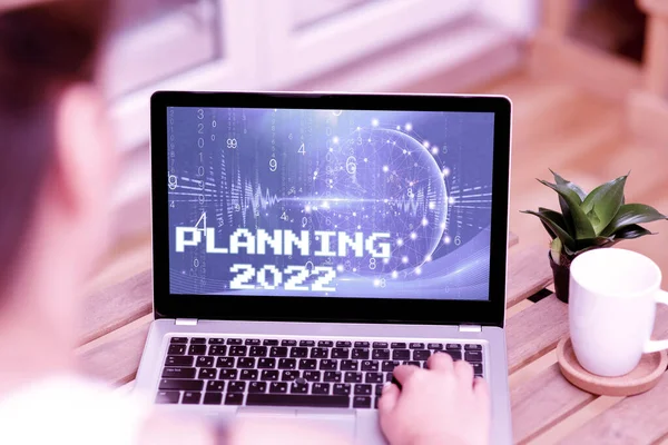 Text bildtext presentera Planering 2022. Affärsidé Börja med slut i Mind Positioning Långsiktiga mål Kvinna skriva på bärbar dator bredvid Coffe Mug och växt arbetar hemifrån. — Stockfoto