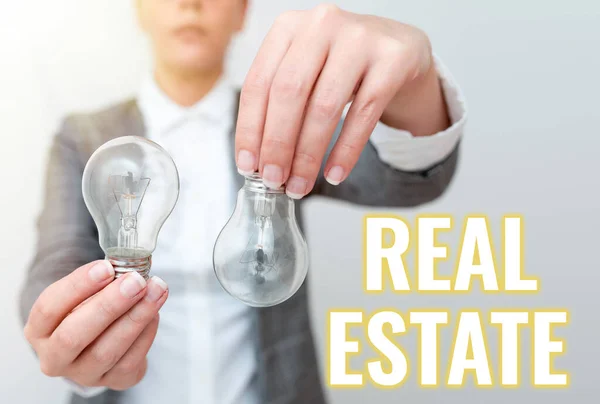Sign displaying Real Estate. Conceptual photo total property consisting of both natural resource and building Lady outfit holding two lamps upside down presenting new technology ideas — Stockfoto