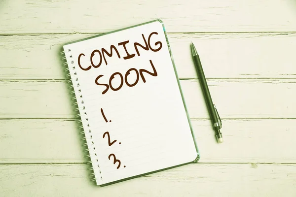 Sign displaying Coming Soon. Concept meaning an event that is bound to happen in the future or about to come Keyboard Over A Table Beside A Notebook And Pens With Sticky Notes — Fotografia de Stock