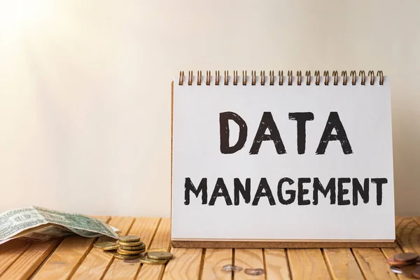 Hand writing sign Data Management. Word for The practice of organizing and maintaining data processes Empty Open Spiral Notebook Beside Stockpile Of Coins On Top Of Desk. — Stockfoto