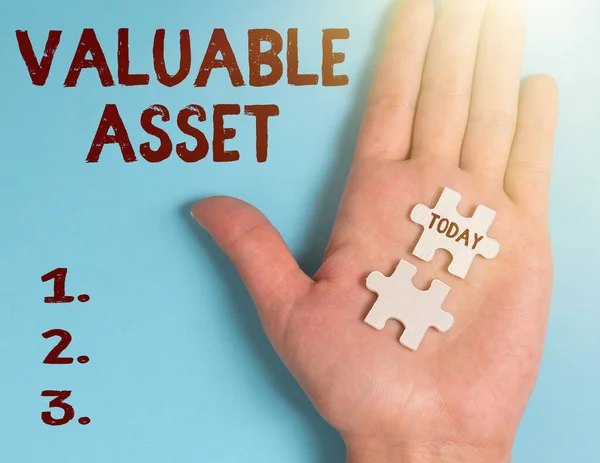 Hand writing sign Valuable Asset. Business approach Your most valuable asset is your ability or capacity Building An Unfinished White Jigsaw Pattern Puzzle With Missing Last Piece — Stock Photo, Image