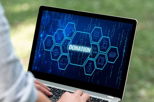 Writing displaying text Donation. Word for something that is given to a charity, especially a sum of money Woman Typing On Laptop Sitting Outside Back View Working From Home. — Foto Stock