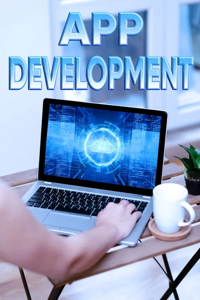 Conceptual display App Development. Word for producing computer software with a specialized purpose Hand Busy Typing On Laptop Beside Coffe Mug And Plant Working From Home. — 图库照片