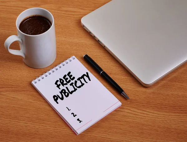 Text showing inspiration Free Publicity. Internet Concept Promotional marketing Mass media Public Relations Editorial Closed Laptop Beside Empty Journal With Pen And Coffee Mug Over Table. — Stock Photo, Image