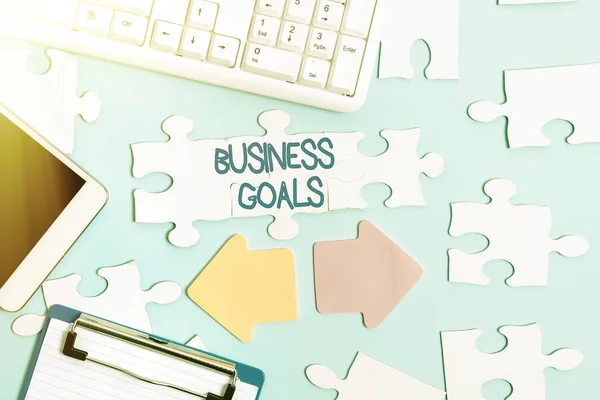 Text sign showing Business Goals. Business concept Expectation to accomplish over a specific period of time Building An Unfinished White Jigsaw Pattern Puzzle With Missing Last Piece — Fotografia de Stock