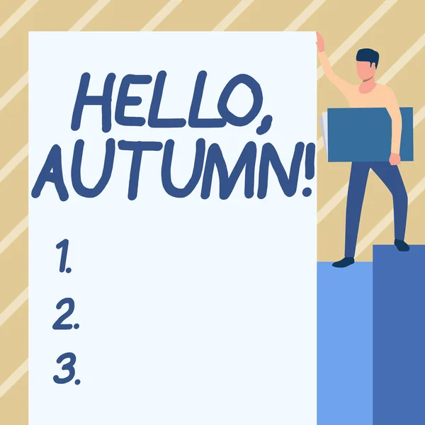 Вывеска "Hello Autumn". Интернет - это время года после лета, когда листья падают с деревьев, человек стоит, неся в руках большой ноутбук, пока снимает Большой Уайтхард. — стоковое фото