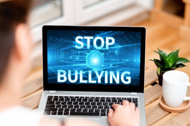 Gösterim metni yazılıyor. Zorbalığı durdurun. İşletme konsepti, kurbanlara yönelik şiddete karşı yürüttükleri kampanyayı Laptop 'ta Kahve fincanı ve Fabrika' nın yanında yazan kadına seslendiriyor..