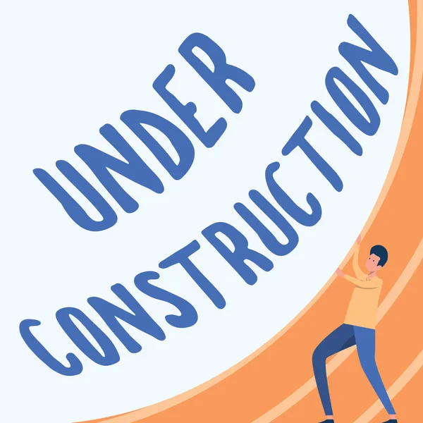 Teksti merkki osoittaa Under Construction. Liikeidean rakentaminen, joka on keskeneräinen, mutta jota aktiivisesti työstetään Gentleman Drawing Standing Pushing Big Circular Object. — kuvapankkivalokuva