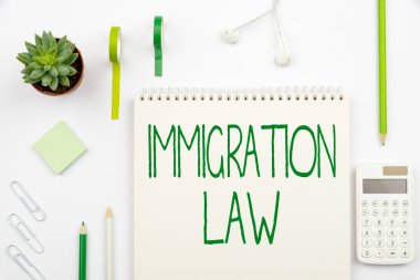 Handwriting text Immigration Law. Business approach Emigration of a citizen shall be lawful in making of travel Multiple Assorted Collection Office Stationery Photo Placed Over Table clipart