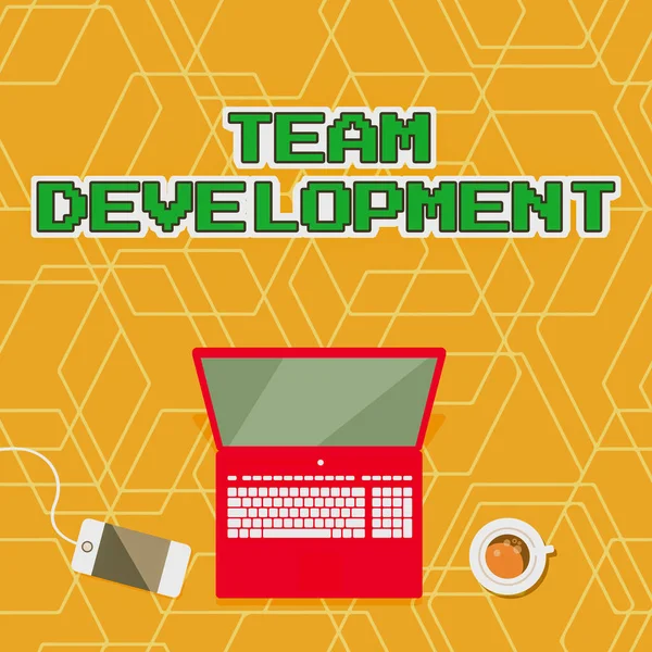 Hand writing sign Team Development. Business concept learn why and how small groups change over time with graphs Laptop Resting On A Table Beside Coffee Mug And Plant Showing Work Process. — Stock Photo, Image