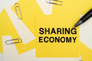 Paylaşımcı Ekonomi 'yi gösteren bir işaret. Mallara erişime dayalı ekonomik model için sözcük Çoklu Koleksiyon Ofisi Kırtasiyesi Fotoğrafı Tablonun Üzerine yerleştirilmiş