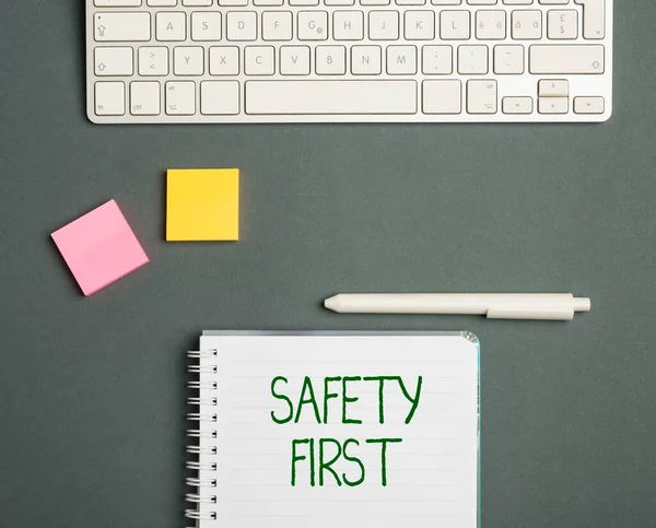 Najpierw podpis "Bezpieczeństwo". Przegląd działalności najlepiej unikać niepotrzebnego ryzyka i działać tak, że pobyt bezpieczny Klawiatura nad stołem obok notebooka i długopisów z lepkimi uwagami — Zdjęcie stockowe