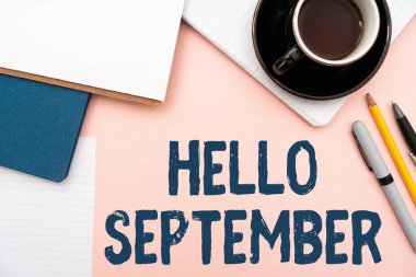 El yazısı. Merhaba Eylül. Kavramsal fotoğraf, Eylül ayı ofis malzemeleri, klavye, bardaklar ve çalışma için kahve fincanlarıyla dolu masaya sıcak bir hoş geldin istiyor.