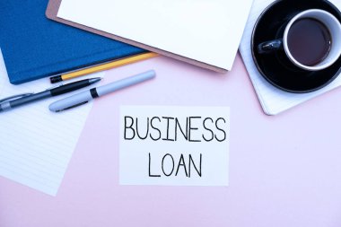 Metin İş Kredisi gösterimi yazılıyor. İş yaklaşımı Kredi İpoteği Finansal Yardım Nakit Avanslar Borç Ofisi Malzemeleri Klavye ve Bardaklar ve Çalışmak İçin Kahve Kupası