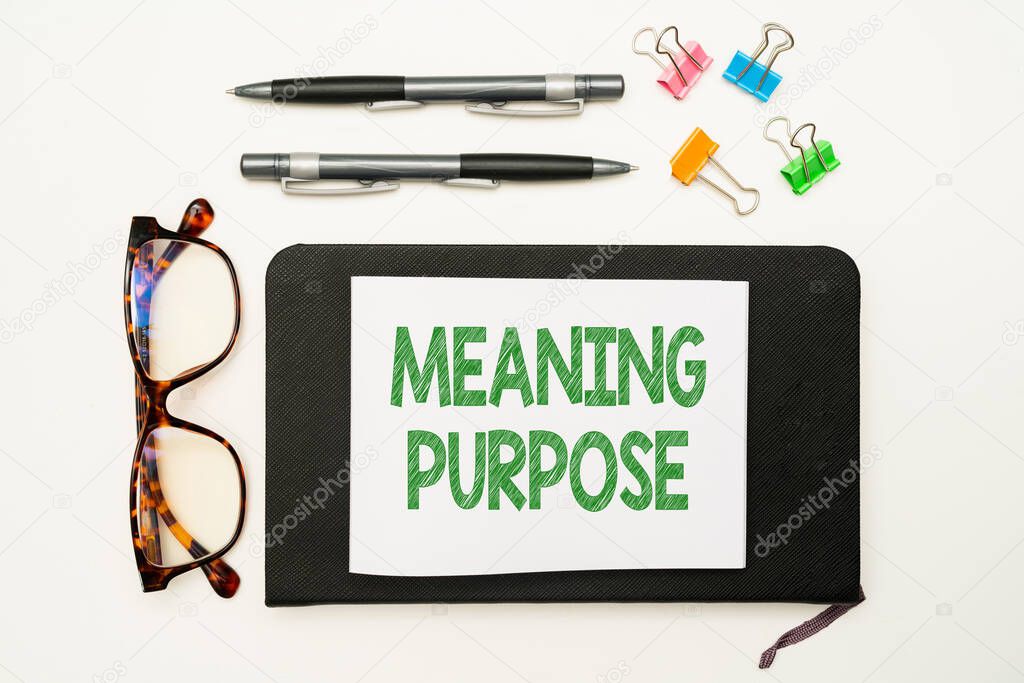 Text caption presenting Meaning Purpose. Word for The reason for which something is done or created and exists Office Supplies Over Desk With Keyboard And Glasses And Coffee Cup For Working