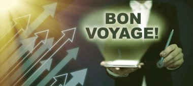 El yazısı metni Bon Voyage, kullanılmış iyi dilekler üzerine yazılmış sözcük yolculuğa çıkmak üzere olan birine iyi dileklerimi iletiyorum. Takım elbiseli bayan elinde kalem tutarak başarılı takım çalışmalarını simgeliyor..
