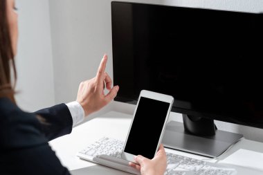 Cep telefonunu elinde tutan ve önemli haberlerde tek parmağıyla işaret eden kadın..