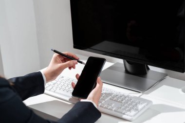 İş kadını, cep telefonunda önemli bir mesajı olan kalemle işaret ediyor.