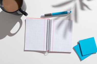 Masanın üzerinde kahve, kalem ve notlarla birlikte yeni fikirlerin olduğu defter..