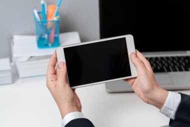 Sitting Businesswoman Holding Mobile Phone With Important Messages.