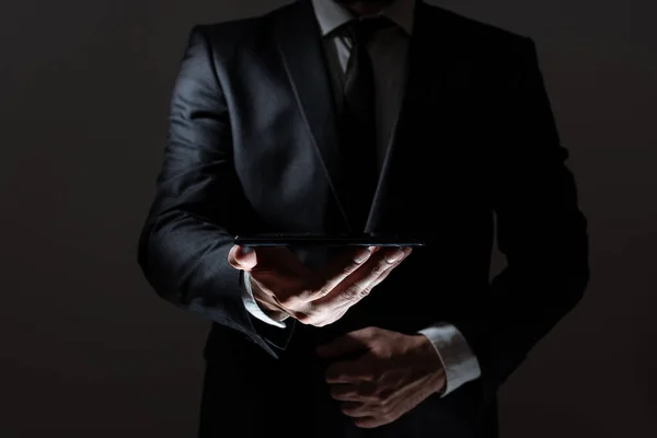 Businessman Holding Tablet With One Hand And Presenting Important Data