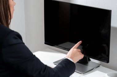 İş kadını, bilgisayarda tek parmağıyla önemli bir bilgiyi işaret ediyor..