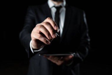 İşadamı Tablet Tutuyor ve Önemli Mesajı Kalemle İşaretliyor.