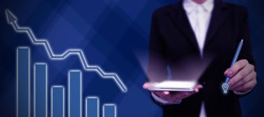 Takım elbiseli kadın elinde kalem tutarak başarılı takım çalışmasını simgeliyor..