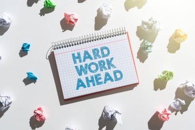 Sign displaying Hard Work Ahead, Business overview A lot of job expected big challenge activities required Notebook With Important Messages Surrounded By Paper Wraps.