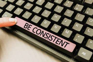 Text caption presenting Be Consistent, Word for Uniform Persistent Firm Unalterable Even Unchanging Rapport Important Ideas Written Under Ripped Cardboard With Paper Wraps Around.