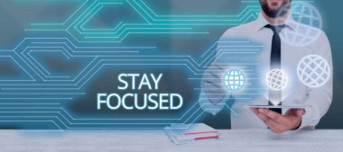 Text caption presenting Stay Focused, Business concept Be attentive Concentrate Prioritize the task Avoid distractions Businessman Holding Tablet And Presenting Crutial Messages In Office.