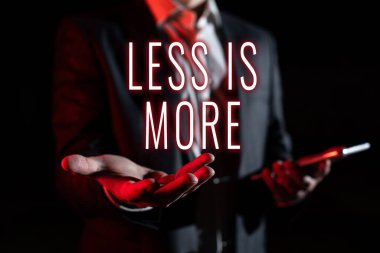 Inspiration showing sign Less Is More, Conceptual photo Minimalist approach to artistic matter is more effective Businessman In Suit Holding New Important Message In One Hand.