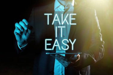 Sign displaying Take It Easy, Business overview Be relaxed do not worry about things stay calmed and rest Hand With Pen Pointing Important Infortmations With Other Holding Tablet
