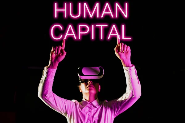 Conceptual caption Human Capital, Business idea Intangible Collective Resources Competence Capital Education Woman Taking Professional Training Through Virtual Reality Goggles.