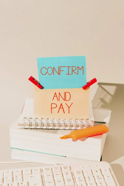 Text sign showing Confirm And Pay, Business concept Check out your purchases and make a payment Confirmation Important Messages Presented On Piece Of Paper On Desk With Books.