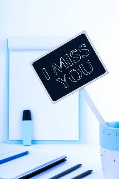 Handwriting text I Miss You, Word for Feeling sad because you are not here anymore loving message Small Blackboard With Important Message In Cup On Desk With Clipboard.