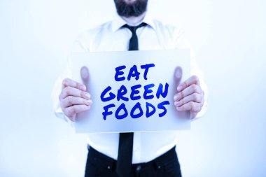 Hand writing sign Eat Green Foods, Business showcase Eating more vegetables healthy diet vegetarian veggie person Businessman With Placard Presenting Important Strategies For Progress.