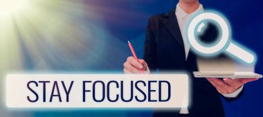 Handwriting text Stay Focused, Business approach Be attentive Concentrate Prioritize the task Avoid distractions Woman Holding A Tablet And Pen Using The Search Bar For Data And Ideas.