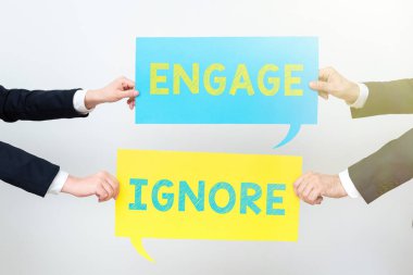 Text caption presenting Engage Ignore, Concept meaning Silent Treatment Manipulative Punishment Sulking Shunning Business Team Holding Two Important Ideas On Speech Bubbles On Both Sides.