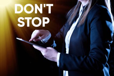 Sign displaying Don T Not Stop, Business concept Continue what had been doing without rendering a delay Businesswoman Holding Tablet In One Hand And Pressing On It.