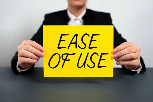 Text sign showing Ease Of Use, Word for User friendly easy to operate simple technology for everybody Businesswoman Holding Note With Important Message On Office Desk.