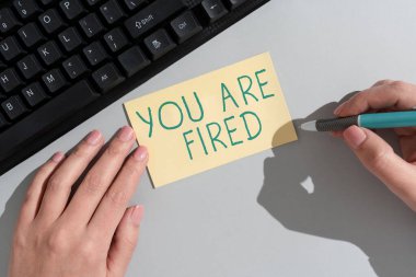 Writing displaying text You Are Fired, Word Written on Getting out from the job and become jobless not end the career Businesswoman Holding Note With Important Message On Office Desk.