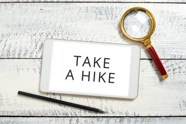 Inspiration showing sign Take A Hike, Conceptual photo Go on an adventure activity backpacking living in nature Tablet Screen With New Ideas With Magnifier And Pencil Around.