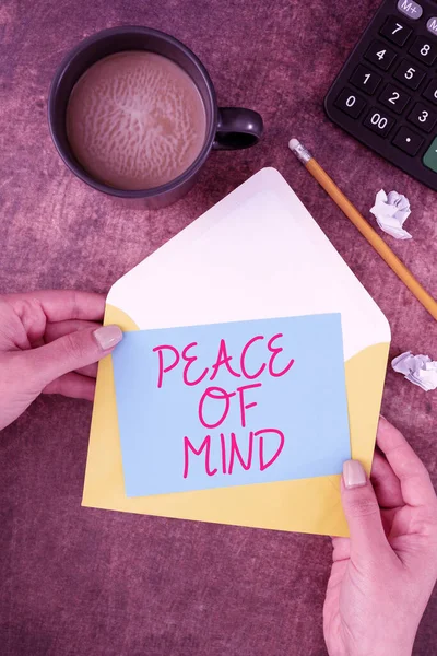 Conceptual display Peace Of Mind, Concept meaning To be peaceful happy with things you have done and accomplish Woman Holding Blank Letter With Coffee And Stationery Over Wood.