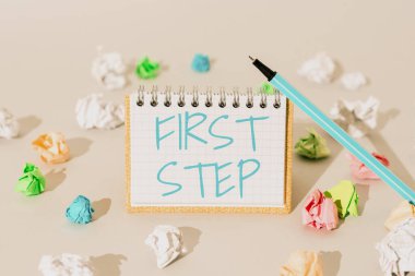 Hand writing sign First Step, Word Written on Pertaining to the start of a certain process or beginning Important Message Presented On Notepad With Paperwraps All Aroud.