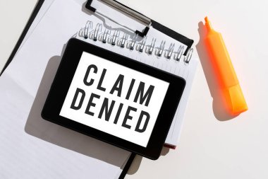 Writing displaying text Claim Denied, Business showcase Requested reimbursement payment for bill has been refused Tablet With Important Message Over Clipboard, Notebook And Marker.